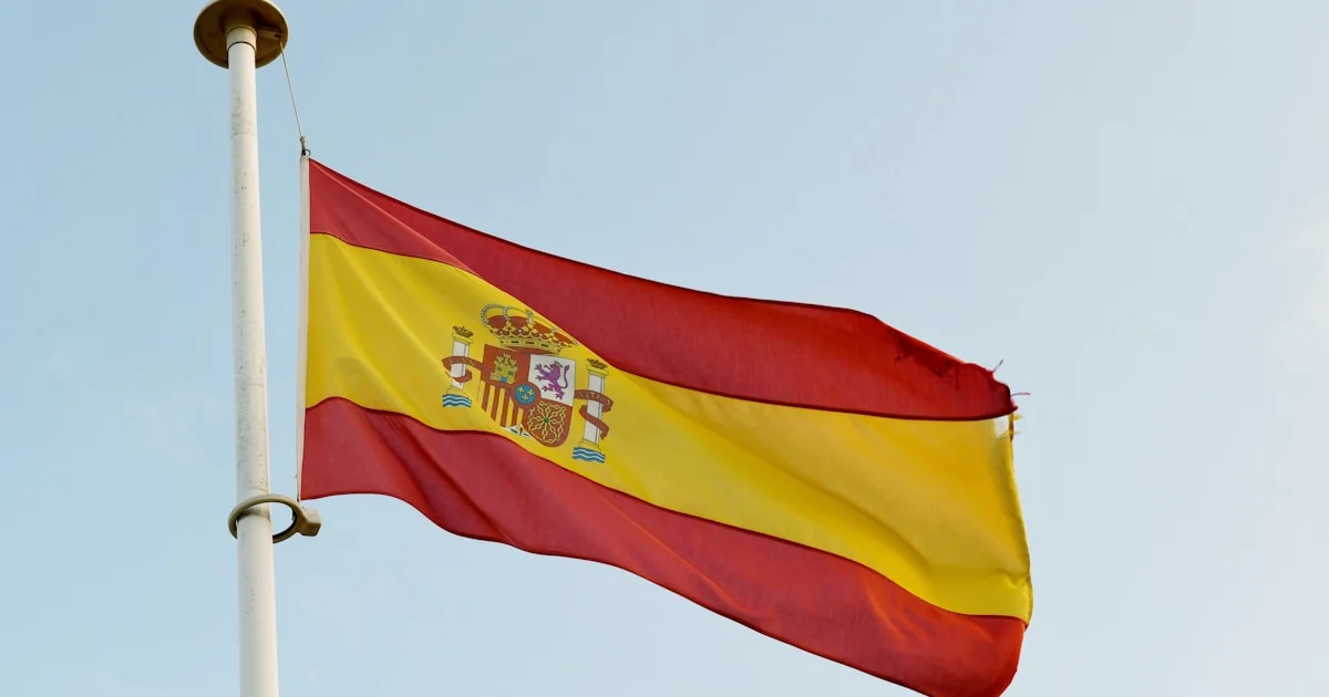 Spanish flag waving in the wind under blue sky