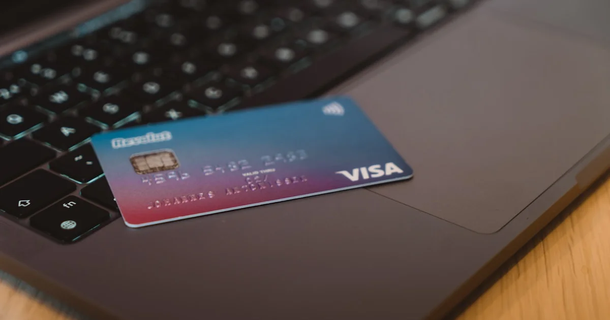 Tarjeta bancaria azul sobre portátil plateado