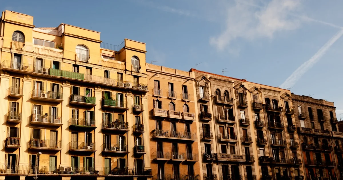 Edificio de apartamentos marrón con balcones y cielo azul